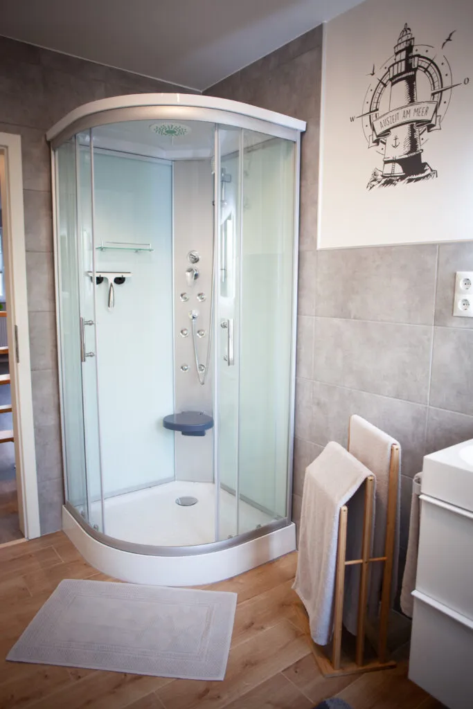 Modernes Badezimmer der Ferienwohnung Canhusen mit großer Dusche, Waschmaschine und Trockner