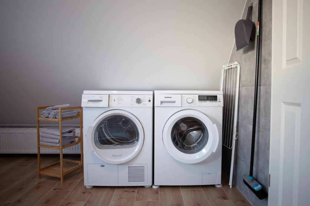 Moderne badkamer van vakantiewoning Canhusen met grote douche, wasmachine en droger