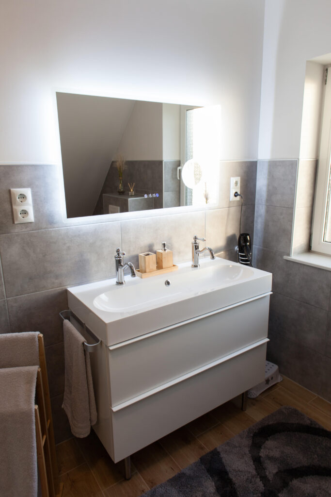 Moderne badkamer van vakantiewoning Canhusen met grote douche, wasmachine en droger