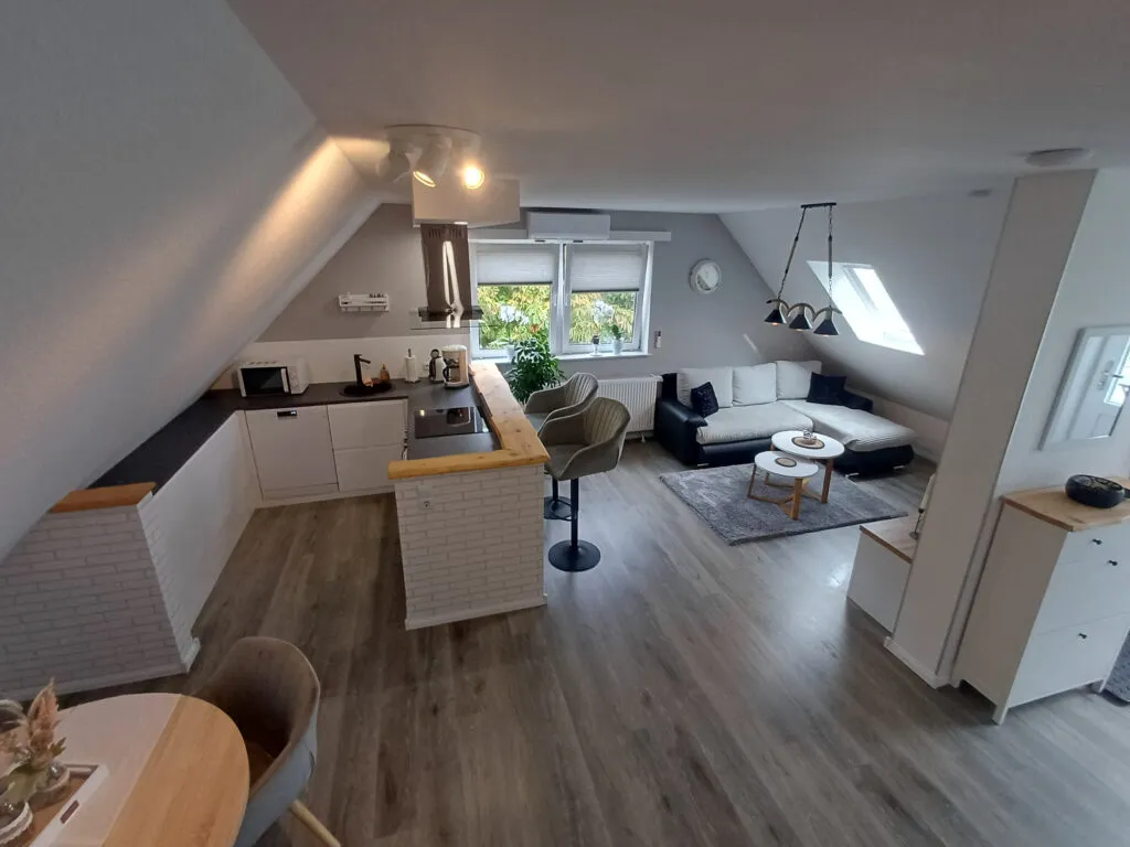 Offener Wohnbereich der Ferienwohnung Canhusen mit Schlafsofa und Smart-TV