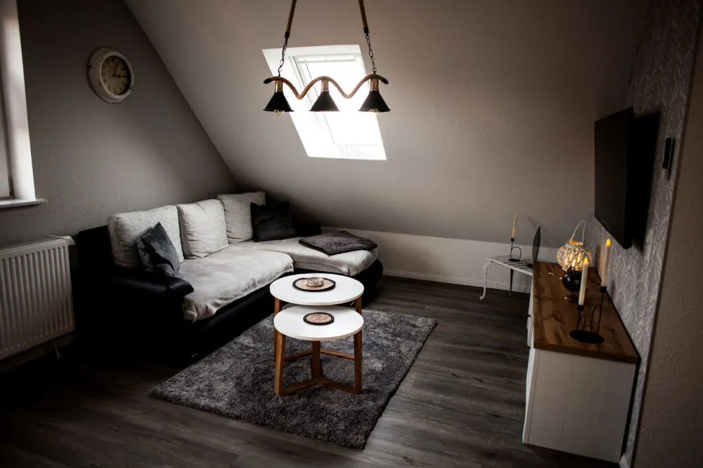 Offener Wohnbereich der Ferienwohnung Canhusen mit Schlafsofa und Smart-TV